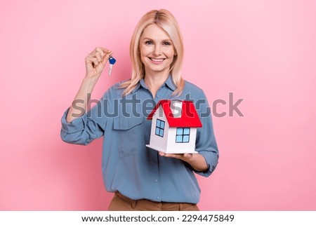 Photo of charming aged lady realtor hold house keychain sell real estate buyer purchase isolated pink color background