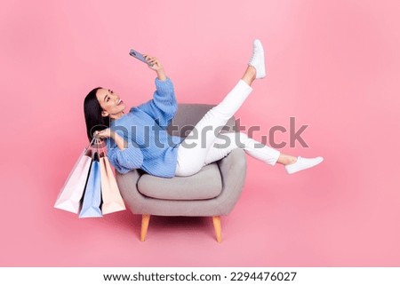 Full body portrait of attractive funny lady sit chair hold mall bags take selfie smart phone isolated on pink color background