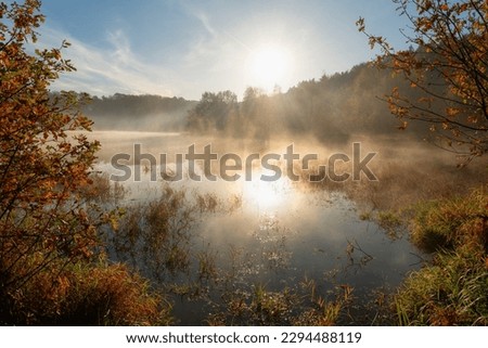 Misty sunrise over the pond in autumn