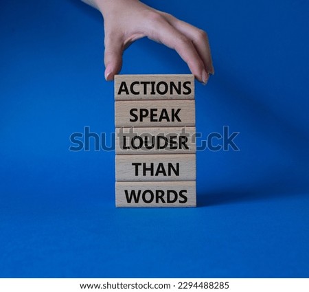 Actions speak louder than Words symbol. Wooden blocks with words Actions speak louder than Words. Beautiful blue background. Businessman hand. Business and Actions concept. Copy space.
