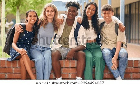 Portrait Of Multi-Cultural Secondary Or High School Students Sitting On Wall Outdoors At School Royalty-Free Stock Photo #2294494037