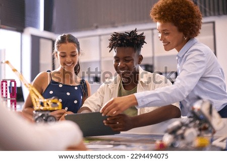 Female High School Teacher With Digital Tablet Helping Students In STEM Technology Lesson Royalty-Free Stock Photo #2294494075