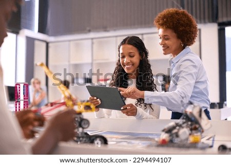 Female High School Teacher With Digital Tablet Helping Teenage Girl In STEM Technology Lesson Royalty-Free Stock Photo #2294494107