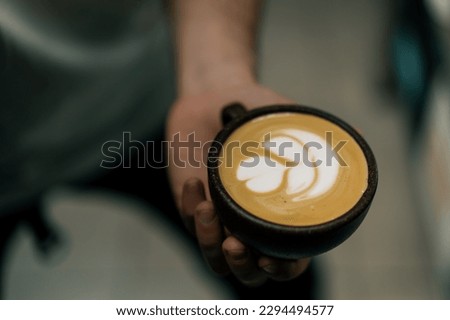 barista serving a customer hot coffee latte in a coffee cup in cafe waiter preparing hot coffee with milk