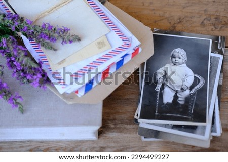 old vintage photographs, bouquet of wild flowers on table wooden table in garden, beautiful blurred natural background with green foliage, concept of genealogy, memory of ancestors, family tree