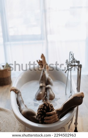 Back view of african american man with vitiligo taking bath with foam at home