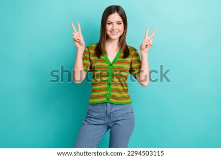 Photo of sweet cute lady wear striped cardigan showing two v-signs isolated turquoise color background
