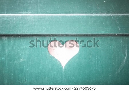 heart shaped cutout in a turquoise shutter on a building