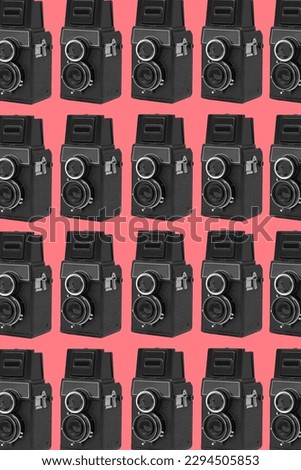 some black retro medium format film cameras arranged in different lines forming a mosaic pink background