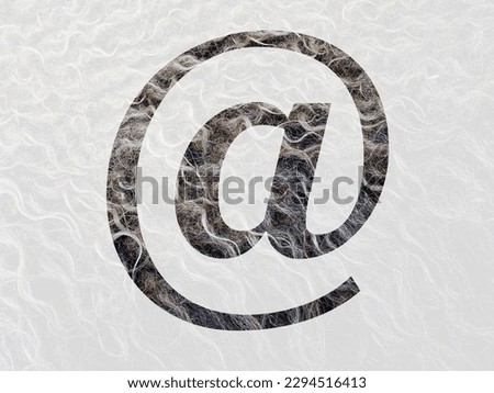mail sign, at sign of the alphabet made with curly hear of the wool of a sheep, with colors brown, white and beige
