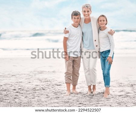 Lighting makes the picture. Shot of a mature woman and her grandchildren bonding at the beach.