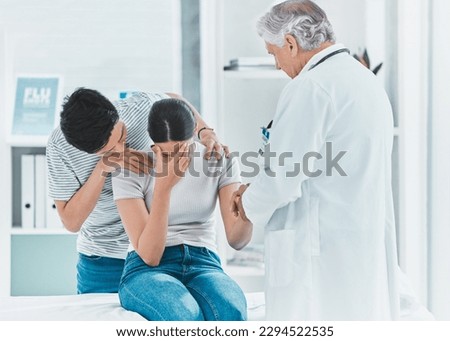 The worst day of their lives. Shot of a young couple receiving bad news from their doctor. Royalty-Free Stock Photo #2294522535