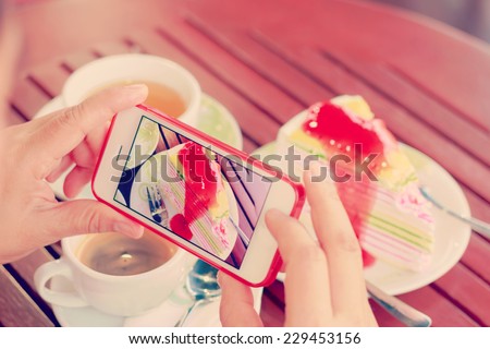 Woman using smartphones to take photos of food with instagram style filter 