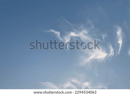 The blue sky and white and orange cirrus clouds blend beautifully. Cloud has a long tail like a peacock feather at Bangkok, Thailand.no focus Royalty-Free Stock Photo #2294534063