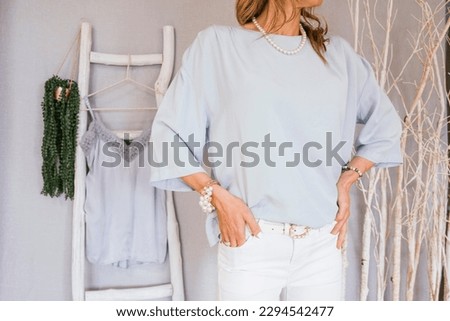 Woman showing clothes that she wants to sell second-hand on a used clothing website.