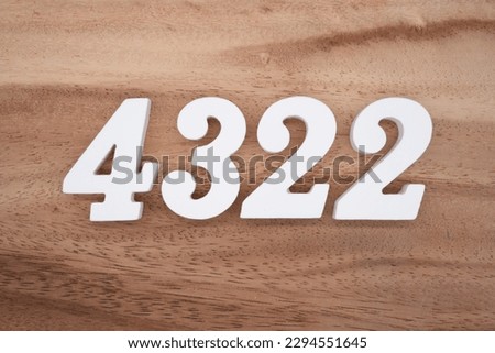 White number 4322 on a brown and light brown wooden background.