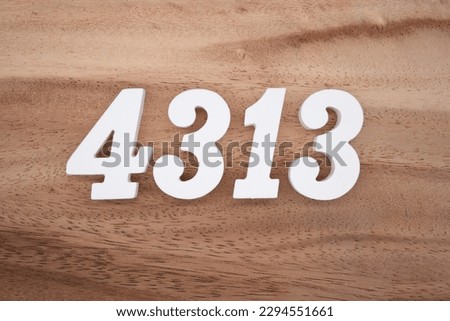 White number 4313 on a brown and light brown wooden background.