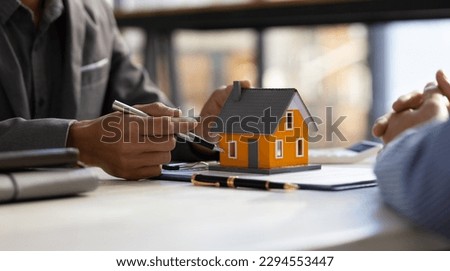 Real estate agent discuss about the terms of the home purchase agreement and asked the customer to sign the documents to make the contract legally, Home sales, lease, mortgage and home insurance.