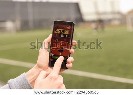 betting bet sport phone gamble over shoulder soccer live website concept.