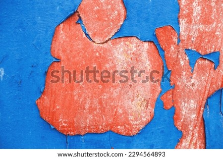 Old blue paint peeling from red concrete wall background. Texture of an old grunge plate with cracked paint with a hole. copy space for your text.