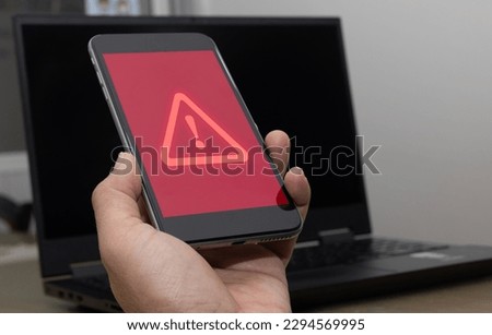 Investment caution, economic situation warning, phishing and internet security concept, businessman using smartphone and laptop with warning sign