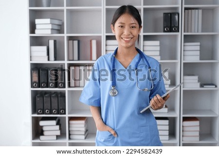 Portrait of young smart medical student smiling to the camera while holding tablet in her hand.