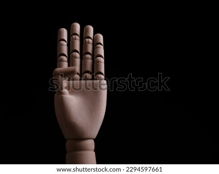 Wooden mannequin hand on black background