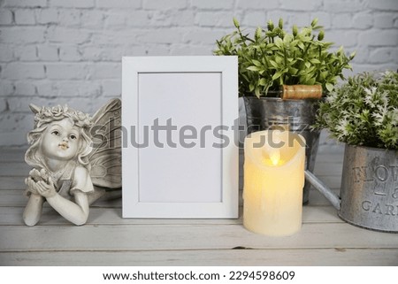 Empty mock up photo frame with LED candle light on white brick wall background