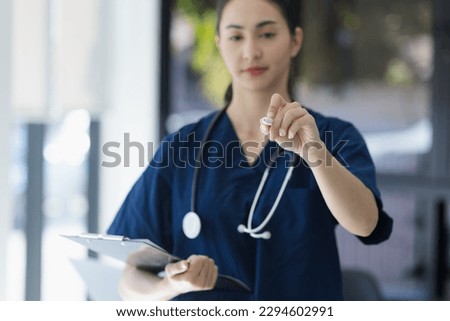Doctor working with clipboard in hospital, Confident nurse with medical record, Healthcare and medicine concept.