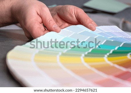 Hands designer or architect choosing swatch the colors painting of the walls in new apartment, design project. Renovation concept. top view. High quality photo