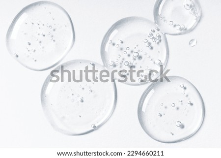Drops and smears of cosmetics. Drops of liquid transparent gel with bubbles on a white background