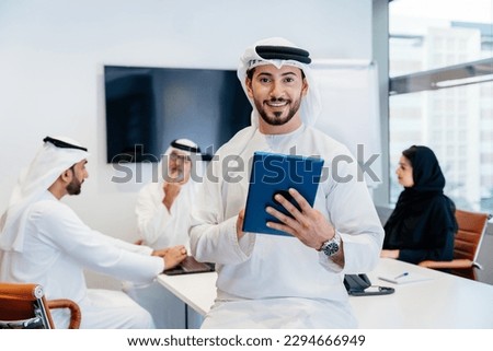 Group of middle-eastern corporate business people wearing traditional emirati clothes meeting in the office in Dubai - Business team working and brainstorming in the UAE Royalty-Free Stock Photo #2294666949