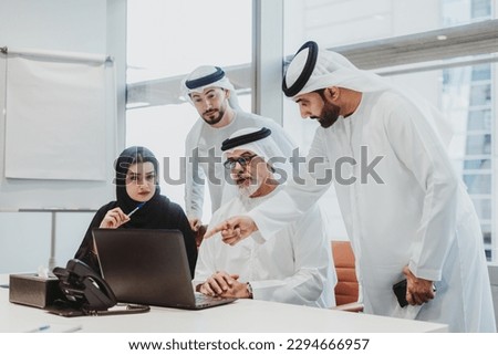 Group of middle-eastern corporate business people wearing traditional emirati clothes meeting in the office in Dubai - Business team working and brainstorming in the UAE Royalty-Free Stock Photo #2294666957