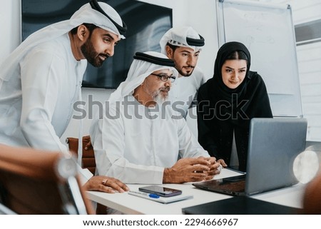 Group of middle-eastern corporate business people wearing traditional emirati clothes meeting in the office in Dubai - Business team working and brainstorming in the UAE Royalty-Free Stock Photo #2294666967