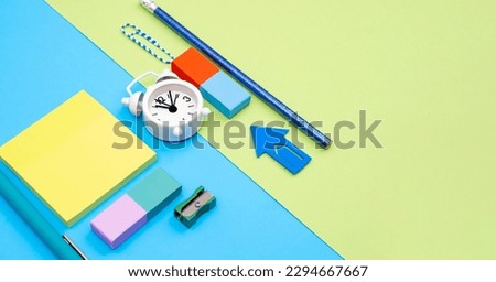 Avant-garde office background with stationery and clock as a concept for work presence and time management