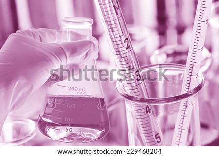 male chemist holding flask at laboratory.