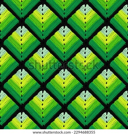 Seamless knitted pattern in the form of green gradient rhombuses is crocheted with multi-colored threads. Patchwork style. Acrylic blanket. Royalty-Free Stock Photo #2294688355