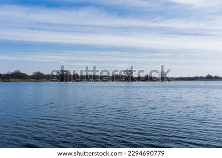 Summer lake background. Small forest pond landscape. Holiday in rural Poland. Cloudy day view. Simple water surface. Empty landscape water reflection. Tranquility cloudscape. Fishing location.