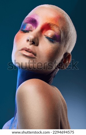 Be you. Be different. Studio shot of a young woman posing with multi-coloured paint on her face. Royalty-Free Stock Photo #2294694575