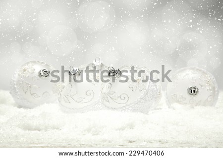silver photo of xmas decoration balls and snow on desk 