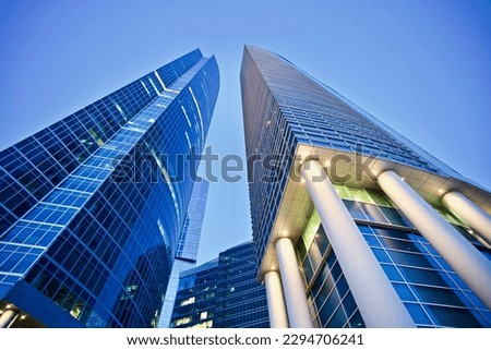 Office and residential skyscrapers on bright sun and clear blue sunset sky background. Commercial real estate. Modern business city district. Office buildings exterior. Financial city district. 