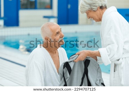 senior couple holding hands in a swimming pool