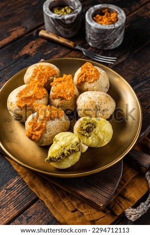 Canary Islands dish Papas Arrugadas wrinkly salty potatoes with and Mojo picon red spicy sauce. Wooden background. Top view Royalty-Free Stock Photo #2294712113
