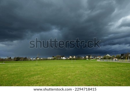 dark storm clouds, scary natural in the sky with a housing estate at the straight horizon