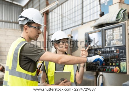 Supporting Engineer team, man and woman use laptop to control and testing an Artificial Intelligent welding robotic automatic arm machine in modern factory. industry 4.0 Technology. 
