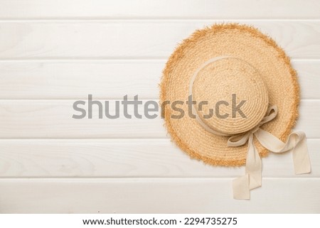 Straw hat on wooden background, top view Royalty-Free Stock Photo #2294735275
