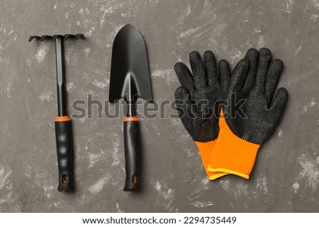 Gardening tools on concrete background, top view