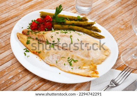 Roasted perch fish fillet served with pickled asparagus and tomatoes Royalty-Free Stock Photo #2294742291