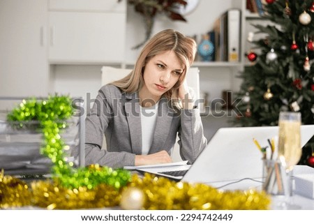 Upset woman manager working at computer during christmas holidays