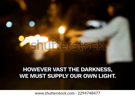 Inspirational life quote on blurry out of focus background. However vast the darkness, we must supply our own light. Royalty-Free Stock Photo #2294748477